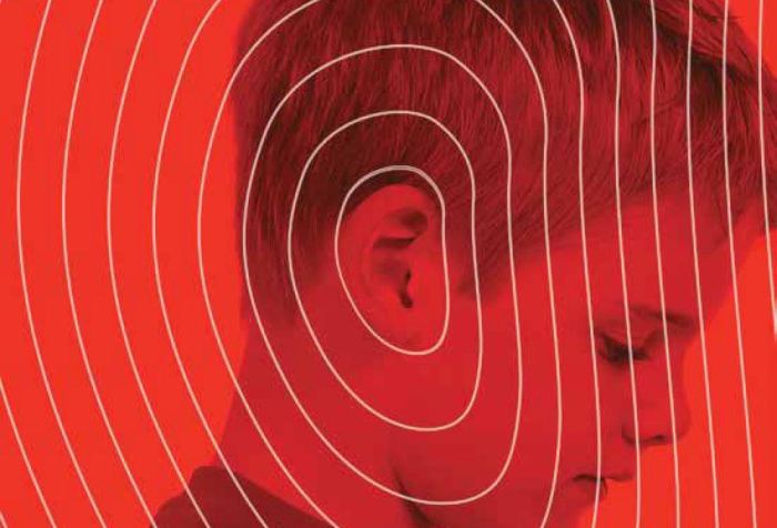 Image description: A book cover featuring a profile photograph of a young, white boy as he looks slightly downward. The picture is a saturated red color with white lines emanating from the boy's ear outward to the edge of the book, suggesting sound waves. Overlaid on that in white letters is the title of the book, Made to Hear: Cochlear Implants and Raising Deaf Children. Below the title appears the name Laura Mauldin.