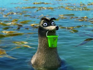 An animated scene from the Pixar film "Finding Dory." Gerald the sea lion in a kelp bed holding a green plastic pail in his mouth.