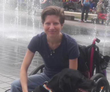 Amanda Siebe, a white woman in a wheelchair and her service dog, Dobby.