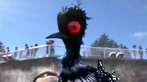 An animated scene from the Pixar film "Finding Dory." Image of Becky the loon, a bird with black and white feathers with white spots and a large red eyeball. 