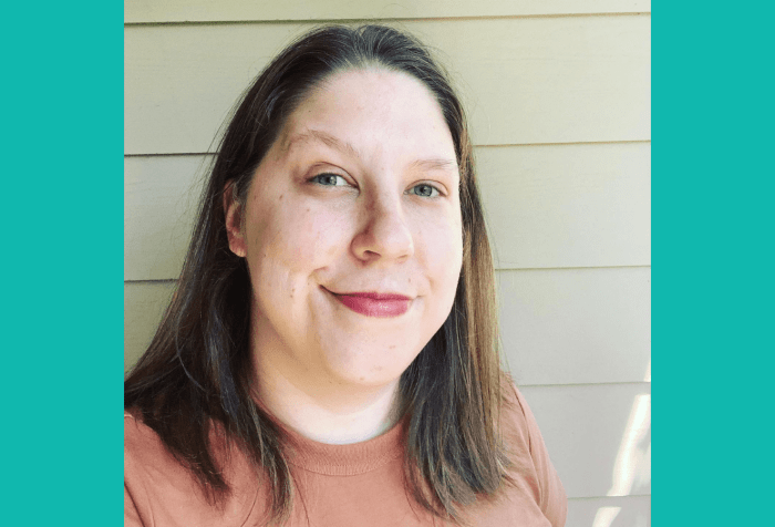 Graphic with a teal background featuring a photo is of Anna, a white nonbinary person with shoulder-length blond hair, standing in front of a beige wall. They wear a muted orange shirt.