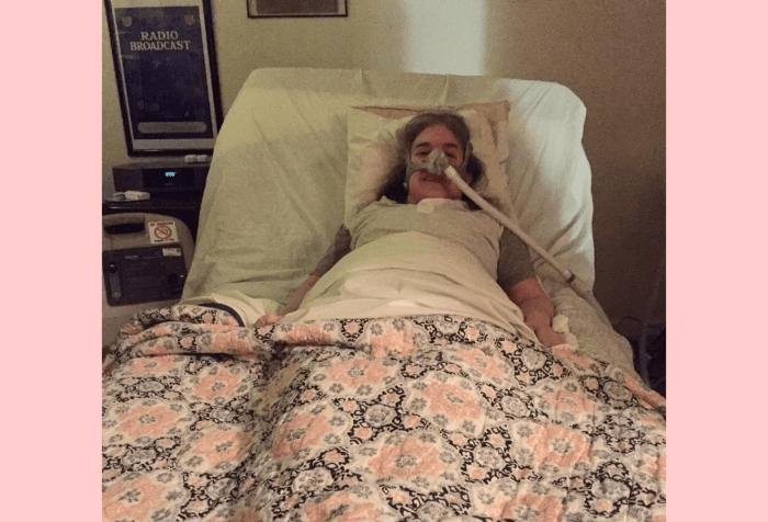 Graphic with a light pink background. In the center, a photo of Ingrid Tischer of her first day home from the hospital. Ingrid is a middle-aged white woman wearing a Bi-Pap mask in a hospital bed under a colorful quilt.