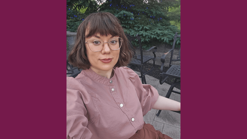 Graphic with a plum colored background. In the center a photo of a young white woman sits outdoors, smiling at the camera. Her brown hair is cut in a long bob with bangs and she has oversized rose-gold glasses. She wears a pink blouse with silver buttons down the front and brown slacks. In the background you can see a patio with iron chairs, and a fir tree lit up with blue lights for the holidays.